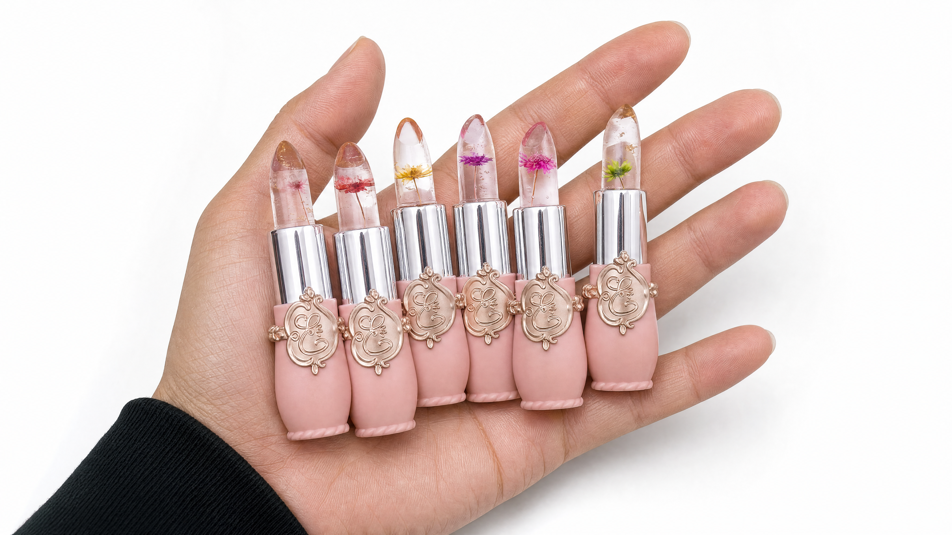 Six Crystal Flower Jelly Lip Balms held in a hand, each with a real dried flower set inside the clear balm