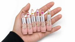 Six Crystal Flower Jelly Lip Balms held in a hand, each with a real dried flower set inside the clear balm